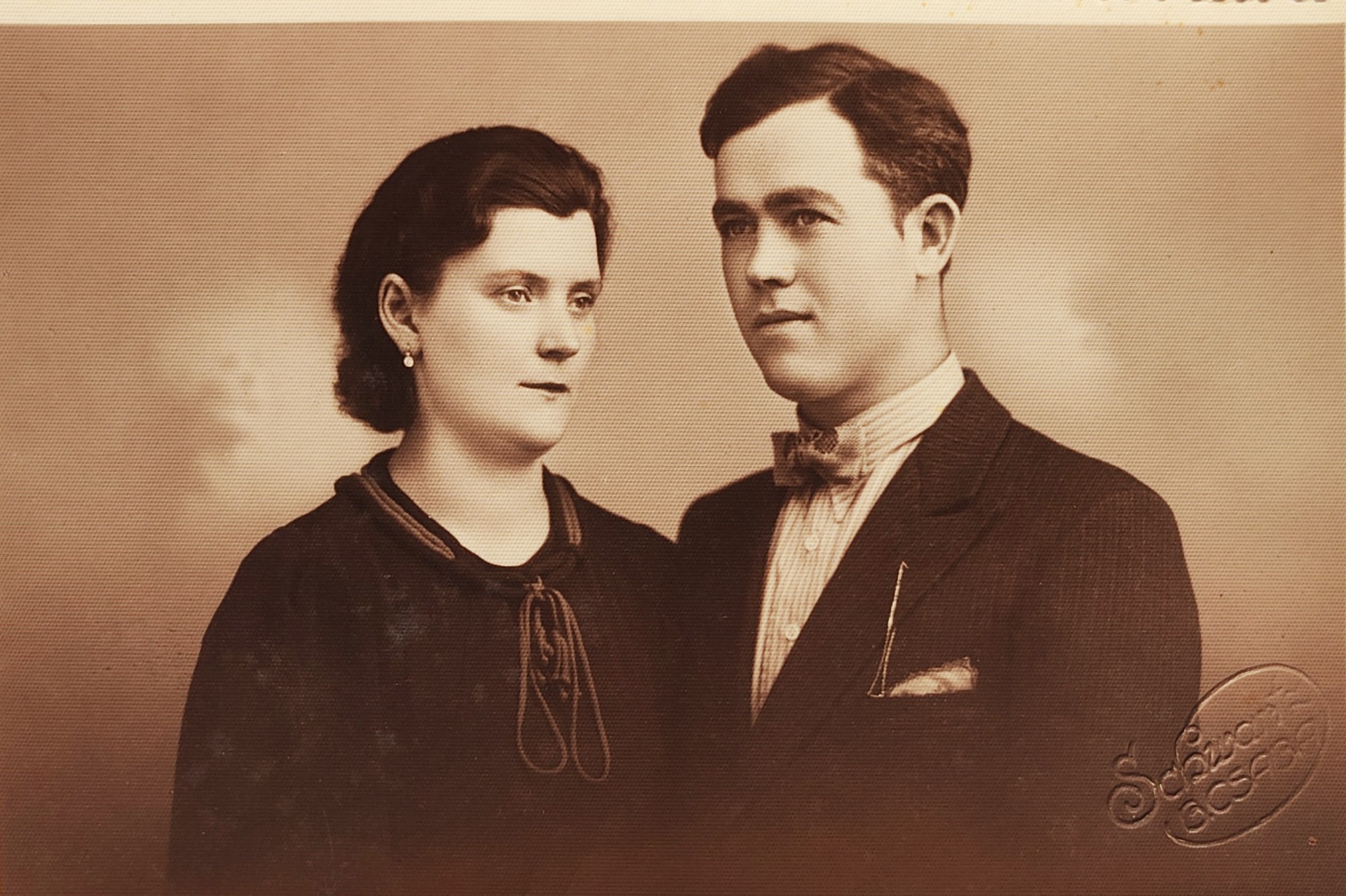Férfi és nő klasszikus portréja, sötét öltönyben és ruhában, egymás mellett, vintage stílusban.